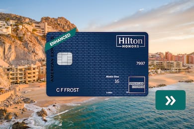 The Hilton Honors American Express Aspire Card with a beach in the background