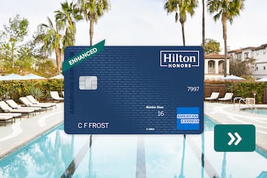The Hilton Honors American Express Surpass® Card with a pool in the background